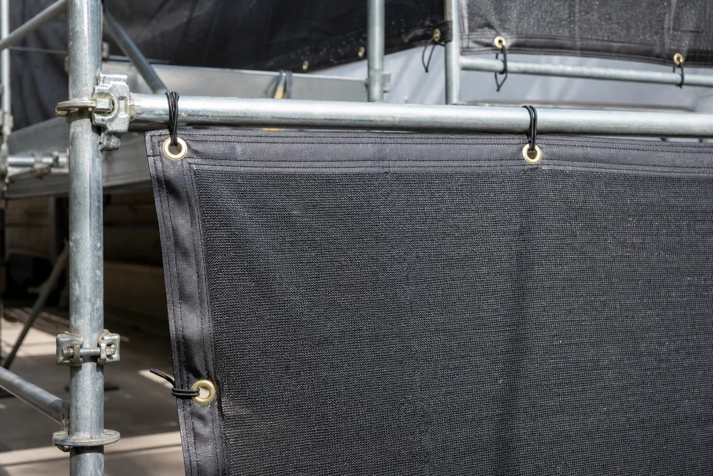 scaffold tarp fastening details with reinforced edges and grommets