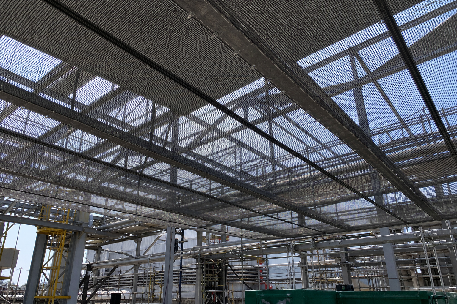 Custom mesh tarp installed for industrial shade and ventilation over a work area