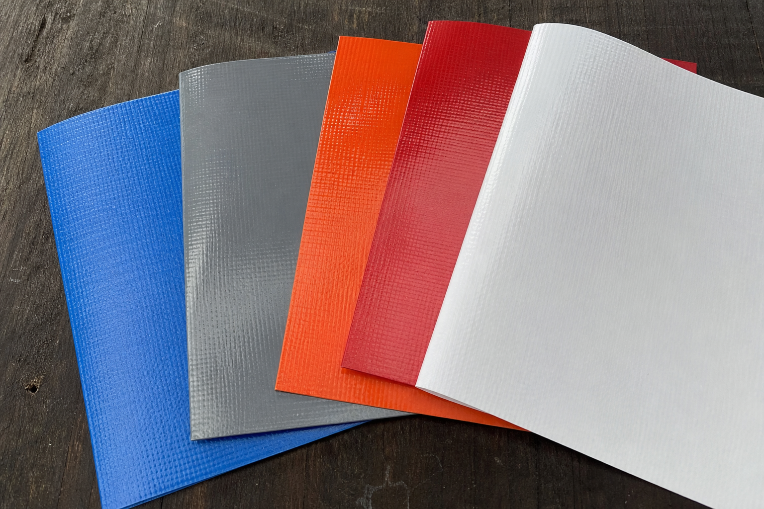 Close-up of colored PVC tarp swatches for outdoor tarp colorfastness and surface comparison