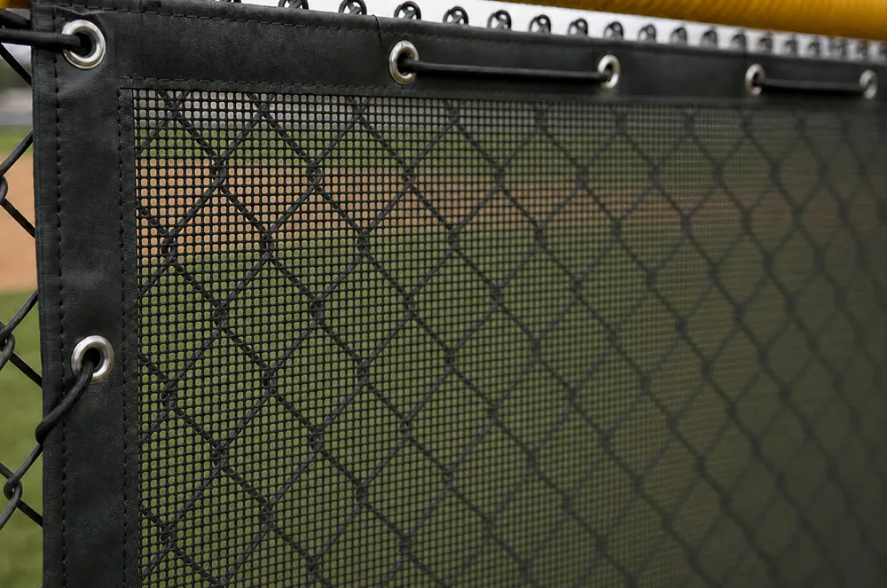 Black mesh panel laced through reinforced eyelets onto an existing chain-link fence