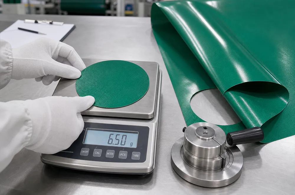 Coated tarp material sample being weighed during a production quality check