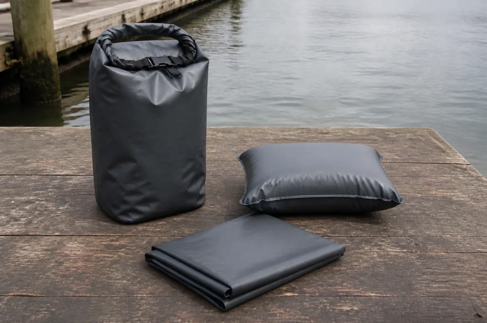 Unbranded dry bag and simple inflatable cushion in a neutral technical equipment staging scene