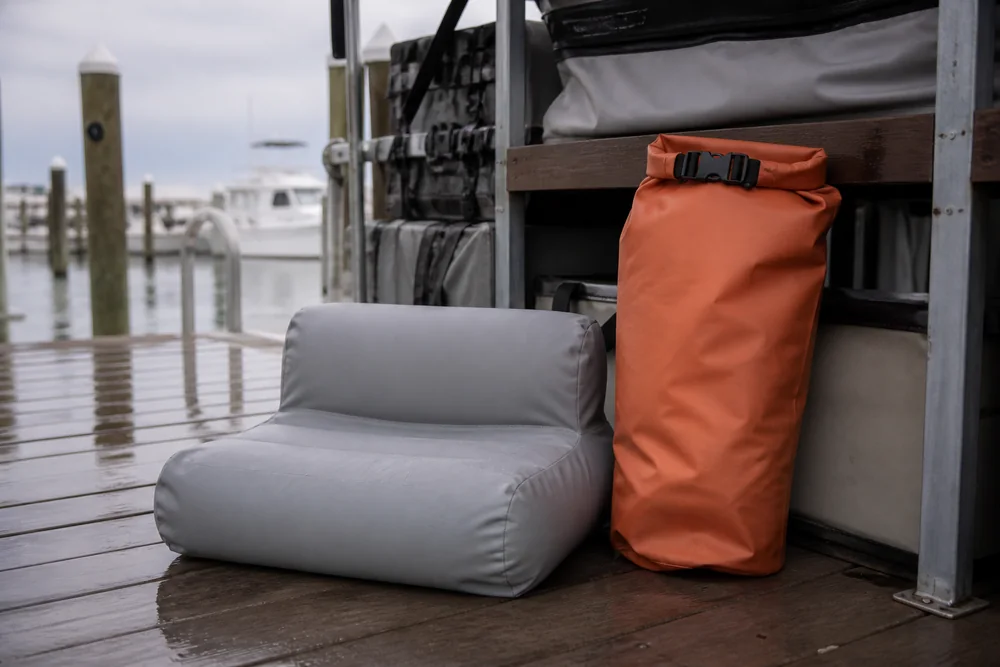 Unbranded inflatable marine product and dry bag in a dockside equipment staging scene