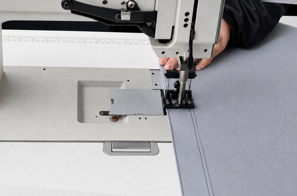 Industrial sewing machine forming a reinforced seam in coated tarp material